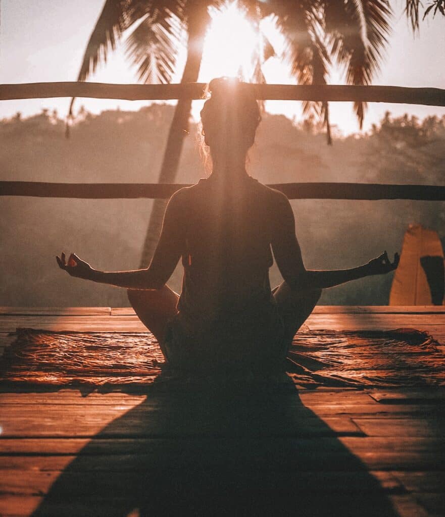 woman doing yoga meditation on brown parquet flooring. zen relaxation