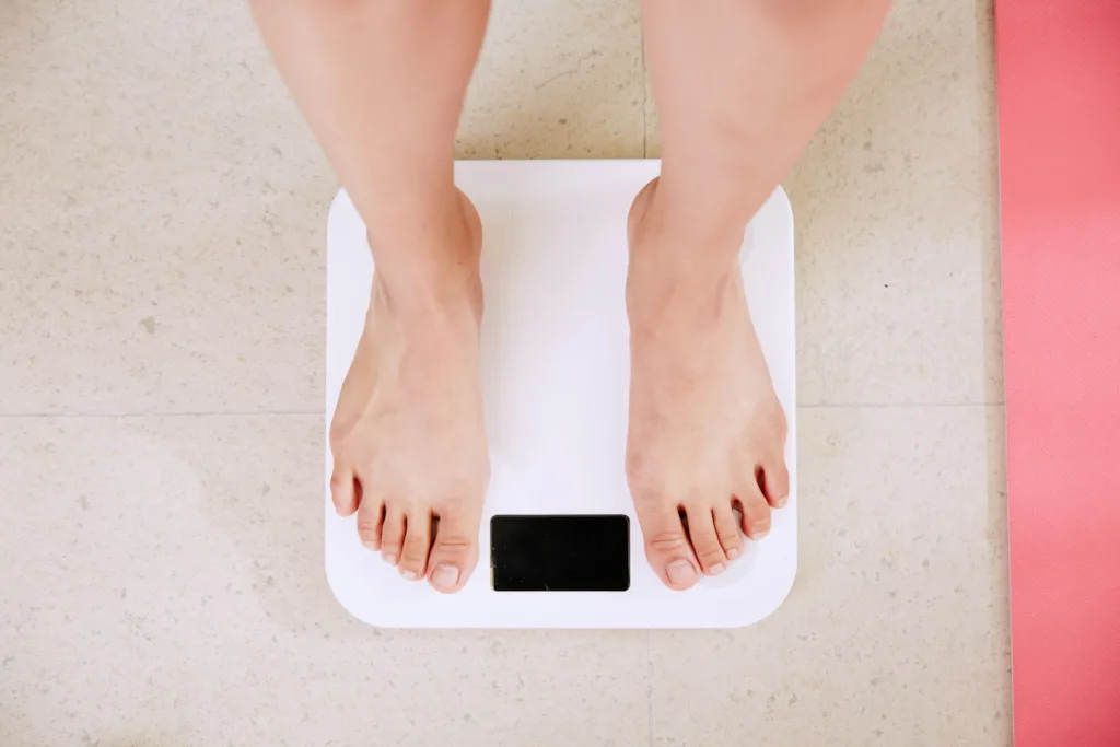person standing on white digital bathroom scale. 6 Week Diet Plan to Lose 20 Pounds